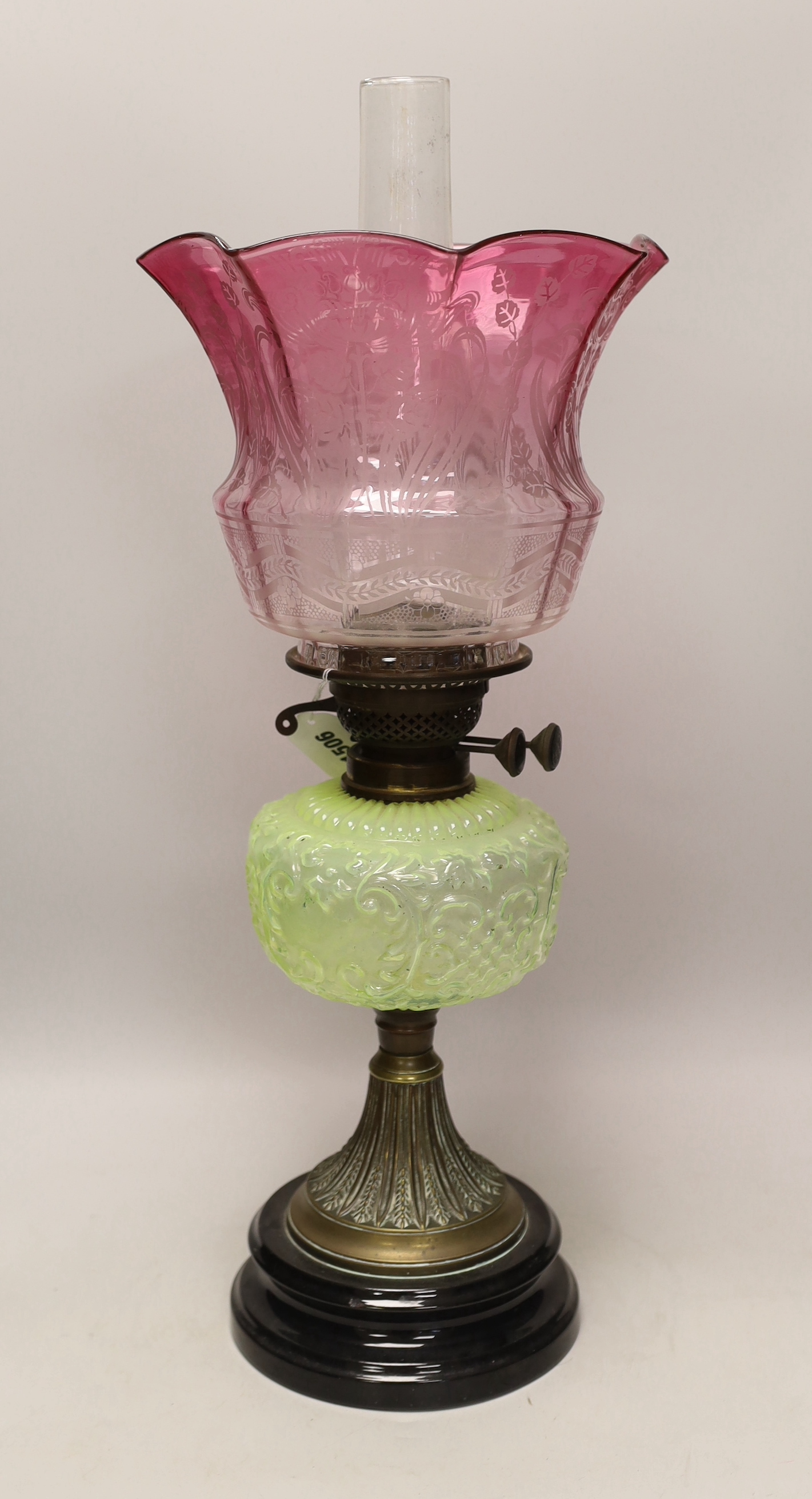 A Victorian brass and glass oil lamp, with cranberry shade, 58cm high including funnel